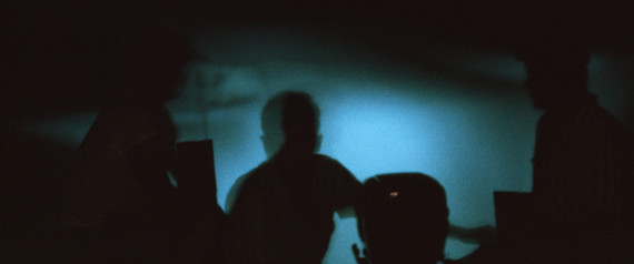 A boatman's motor churns a glowing wake of dinoflagellates